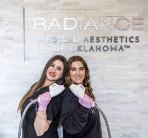 two women holding sciton lasers